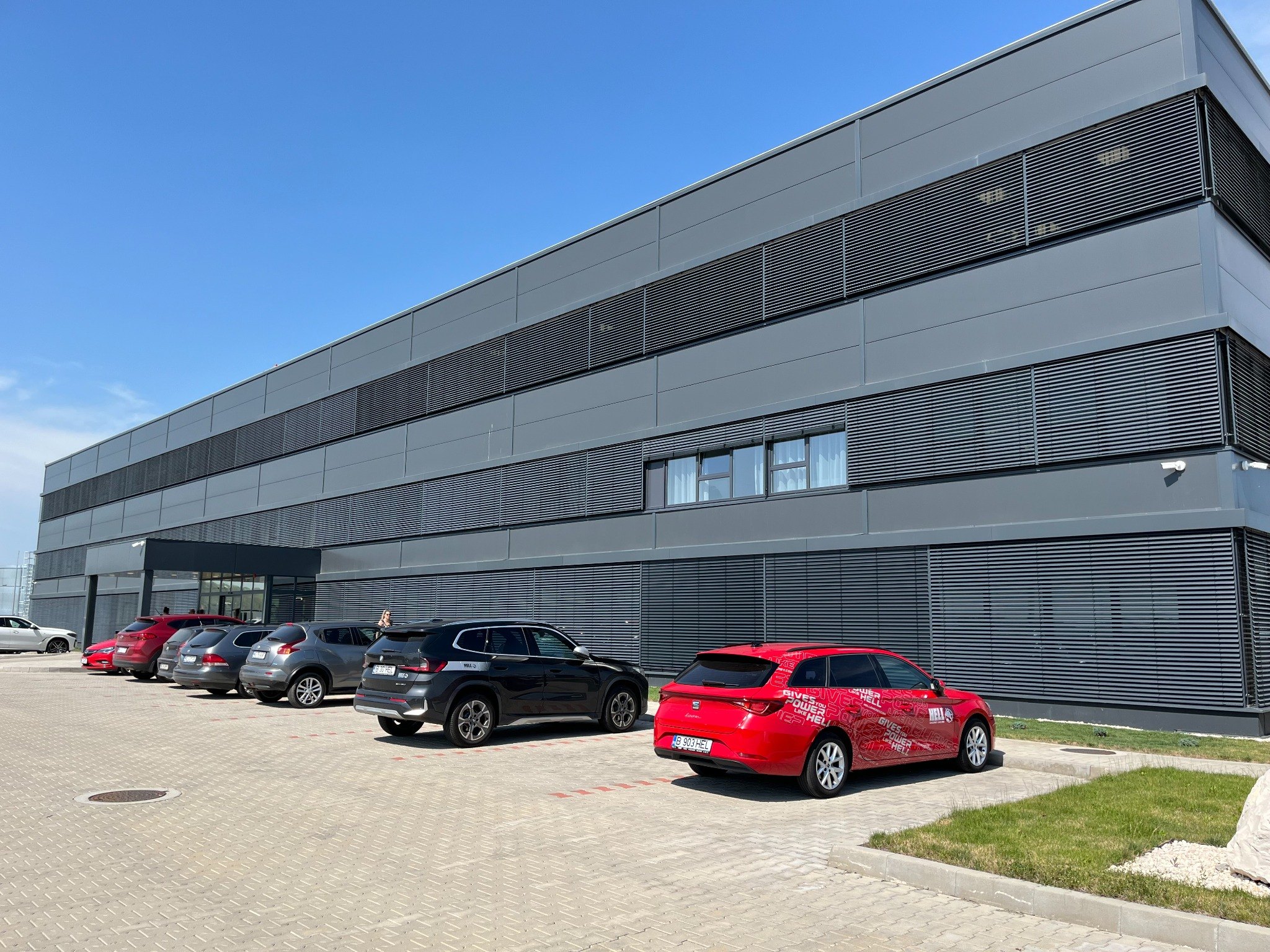 Modern logisztikai raktárcsarnok homlokzata parkolóval